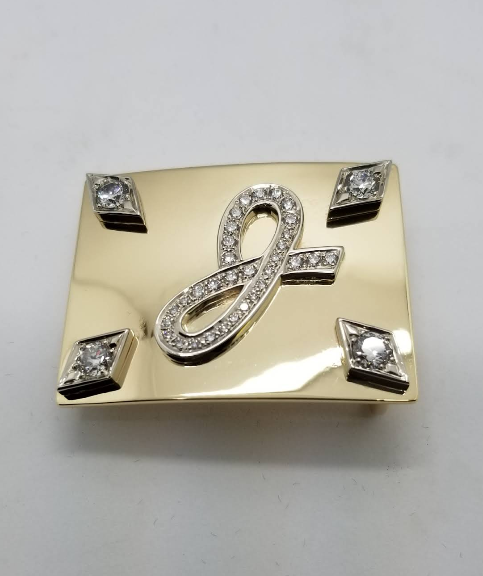 Gold belt buckle with diamond monogram and corner stones